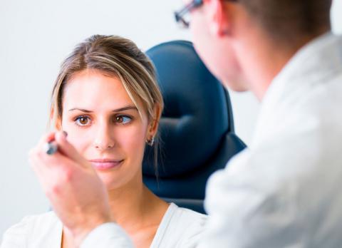 Un oftalmólogo examina los ojos de una paciente