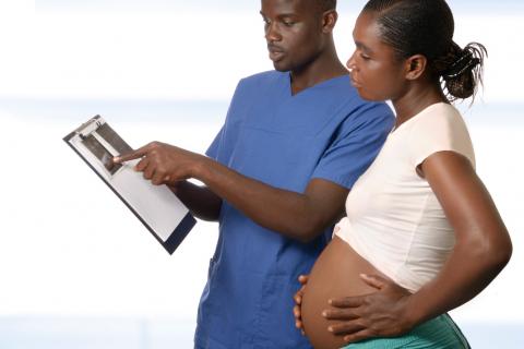 Un médico muestra el resultado de una prueba a una mujer embarazada