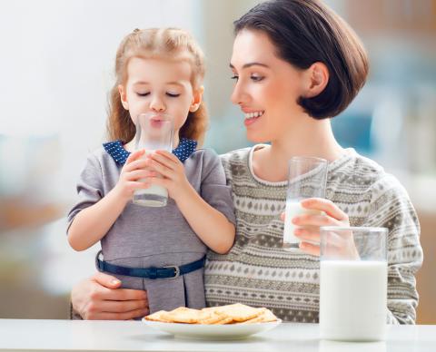 Madre e hija bebiendo un vaso de leche