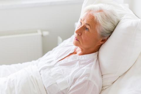 Mujer mayor en la cama con síntomas de depresión