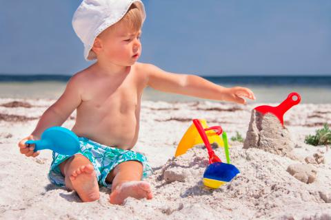 Niño jugando con la arena de playa