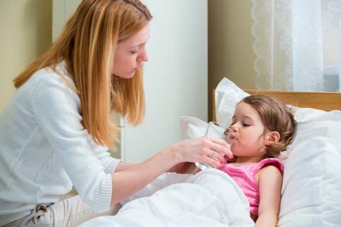 Madre dando agua a su hija para recuperarse del norovirus