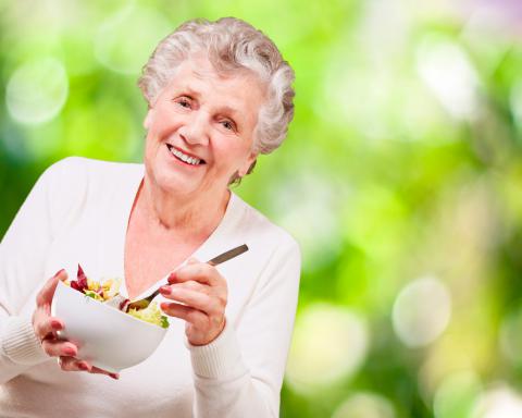 Una mujer mayor a punto de tomarse una ensalada