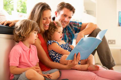 Una pareja leyendo cuentos a sus hijos