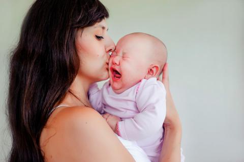 Madre coge en brazos a bebé que llora