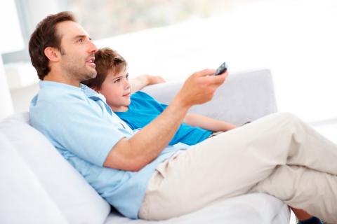 Un padre y su hijo ven juntos la televisión