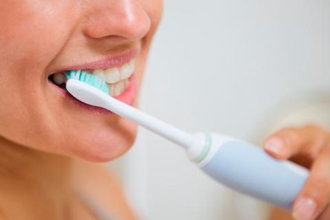 Mujer con hipersensibilidad cepillándose los dientes