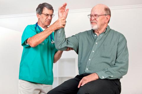 Un médico examina el brazo a un hombre mayor