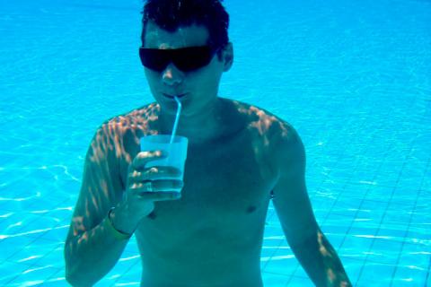 Hombre bebiendo en pajita debajo del agua