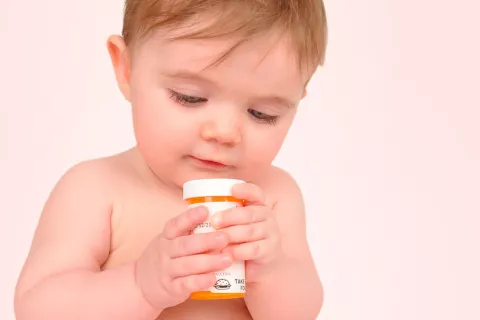 Bebé coge un bote de pastillas
