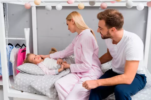 Padres con su hijo en la cama