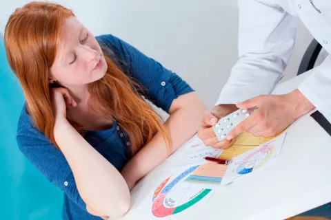 Mujer en consulta ginecólogo para suplementación farmacológica