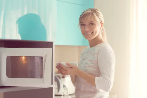 Mujer cocinando con el microondas