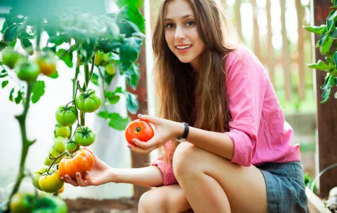 Joven cultivando su propio huerto en casa