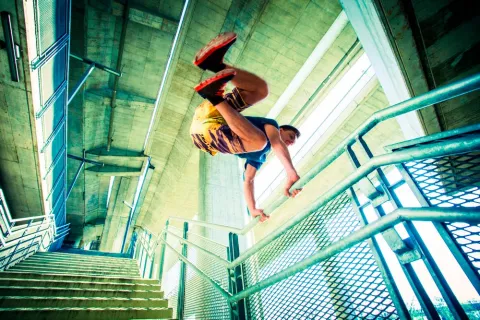 Persona practicando parkour con una barandilla