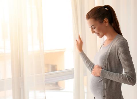 Embarazada ventilando la habitación para evitar alergias