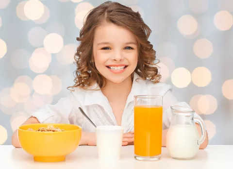 Niña tomando un ejemplo de desayuno saludable y sencillo