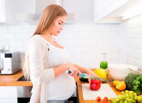 Embarazada cocinando de forma saludable