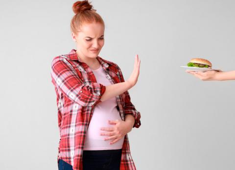 Una embarazada rechaza una hamburguesa con cara de asco