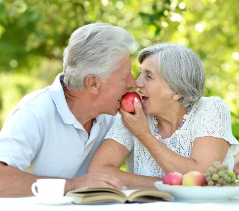 Consejos nutricionales para mayores con las piernas hinchadas Pareja mayor comiendo fruta