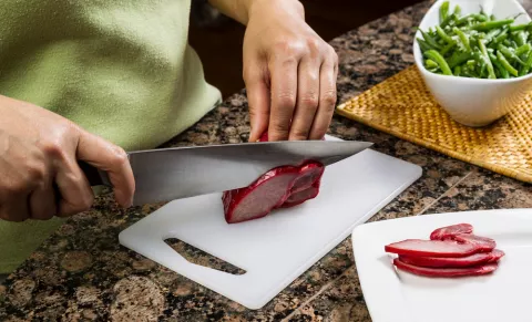 Persona usando una tabla de cortar alimentos