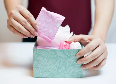 Primera menstruación tras el parto Mujer guardando compresas en una caja