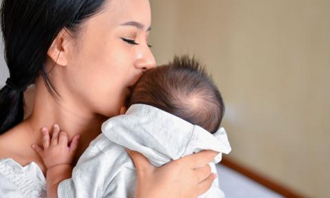 Madre abrazando a su bebé con síndrome de Menkes