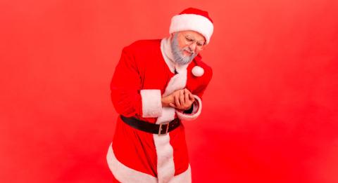 Hombre disfrazado de Santa Claus con dolor en el pecho