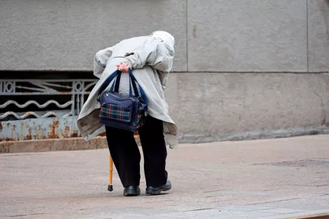 Curvatura de la espalda debido a la edad Mujer de avanzada edad camina con una marcada curvatura de la espalda