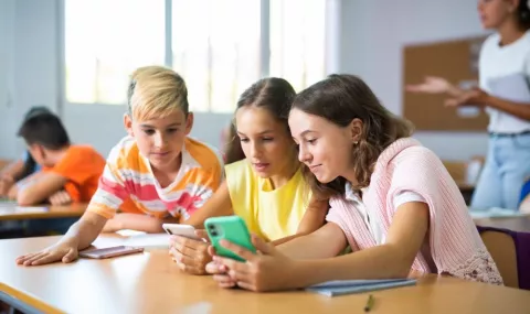 Niños usando grupos de whatsapp en sus smartphones Grupo de escolares consultando whatsapp en sus teléfonos en el colegio