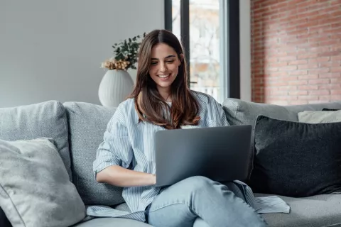 Test ¿Eres una persona disciplinada? Mujer trabajando con su portátil en en salón de su casa