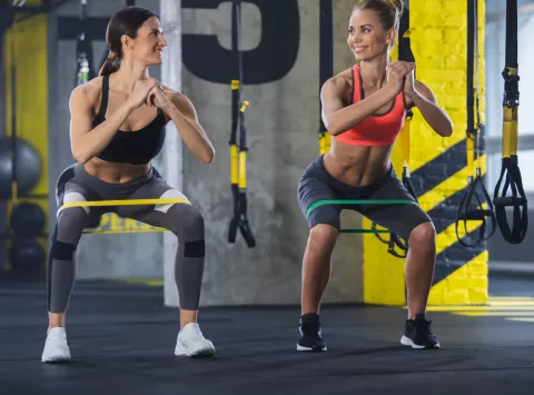 Uso de ropa de compresión en el entrenamiento Dos mujeres en el gimnasio hacen ejercicio usando tops y mallas de compresión
