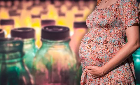 Efecto de los microplásticos en la placenta de la embarazada Embarazada junto a envases que reflejan el peligro de los microplásticos