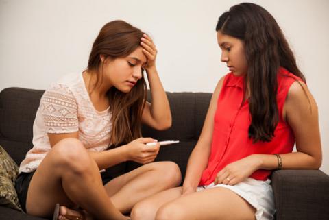 Dos adolescentes observan los resultados de un test de embarazo