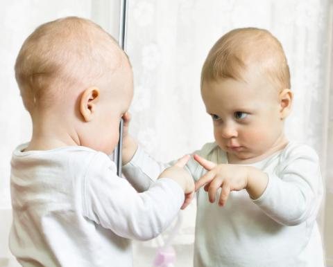 Un bebé se mira en el espejo