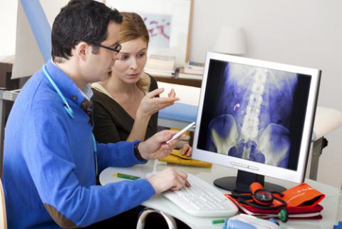 Una mujer observa una radiografía en la consulta del urólogo