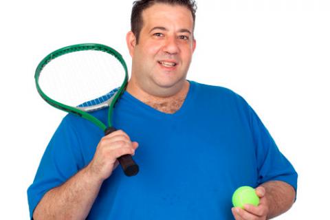 Hombre con sobrepeso con una raqueta y una pelota de tenis en las manos