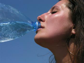 Una mujer bebe agua al aire libre
