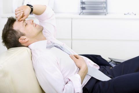 Hombre tumbado con síntomas de cansancio