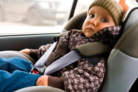 Niño pequeño viaja asegurado por un sistema de retención infantil