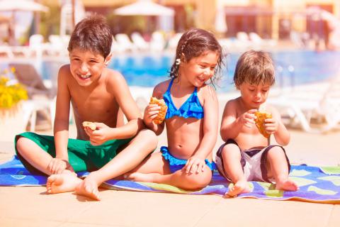 Niños comiendo en la playa antes de bañarse