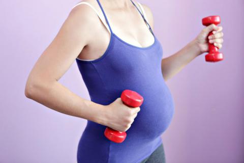 Una embarazada ejercita sus brazos con mancuernas