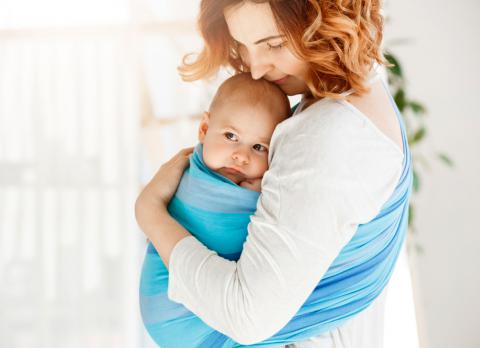 Mujer con su bebé con un sistema de porteo seguro