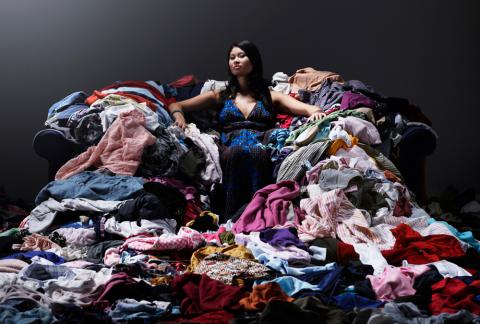 Mujer sentada sobre una pila de ropa