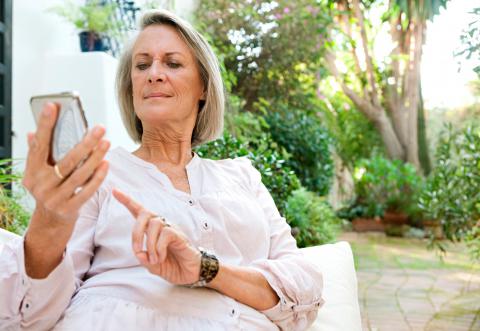 Una mujer mayor usando un teléfono móvil
