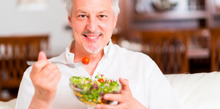 Hombre comiendo un plato de verdura