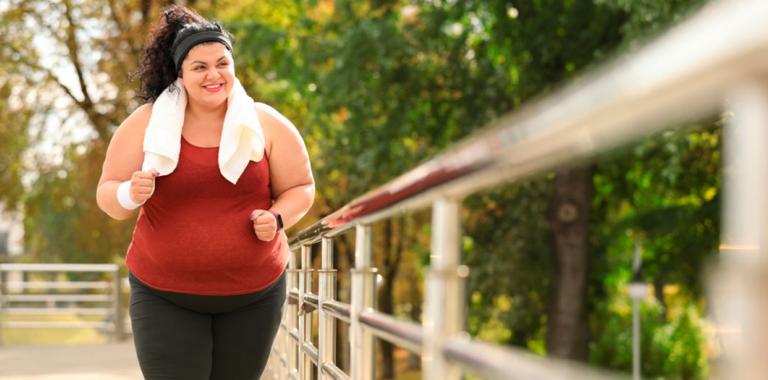 Mujer joven con obesidad haciendo ejercicio en el parque