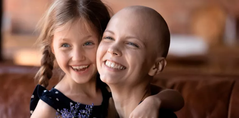 Mujer en tratamiento contra la leucemia sonríe junto a su hija