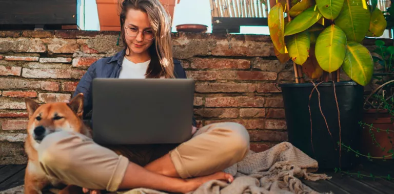 Chica joven estudiando junto a su perro