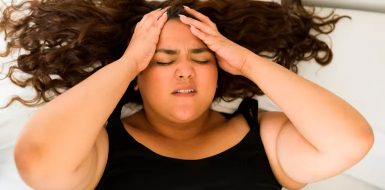 Mujer obesa se lleva las manos a la cabeza